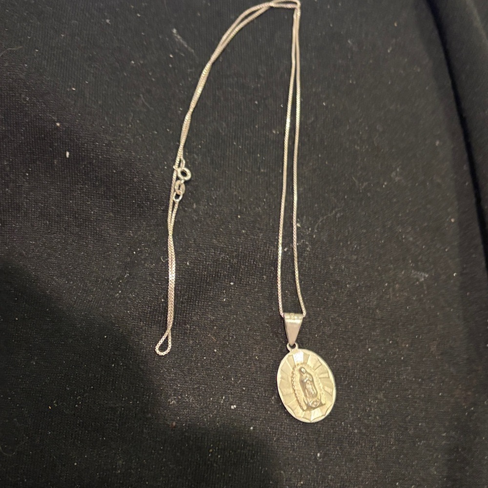 Chic Silver colored Pendant Necklace. Religious face on each side of pendant.